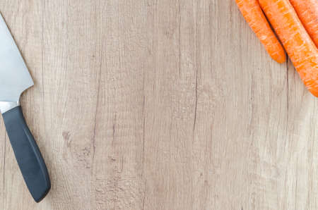 Carrot with knife on wooden tableの写真素材