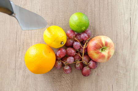 Mix fruits with knife on wooden tableの写真素材