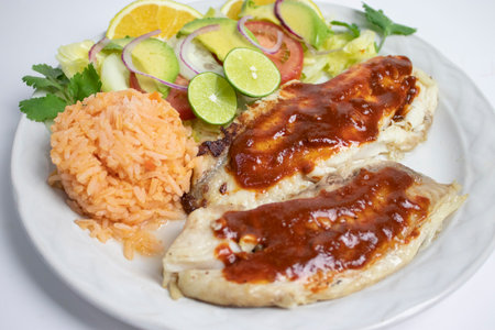 Grilled fish with rice and vegetable salad on a white background.の写真素材