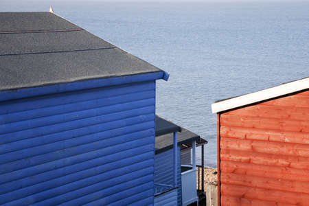 A view of beach huts looking down on their roofing to the beach.の写真素材
