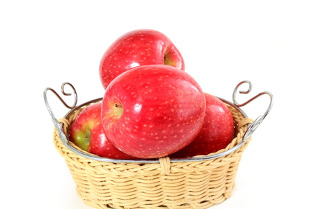 red apple in bamboo basket on white backgroundの写真素材