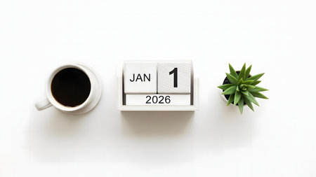 A white desk calendar displaying 'JAN 1 2026' sits between a white cup of black coffee and a small green succulent plant, all on a clean white surface.の素材