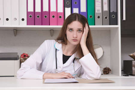 I'm a doctor and I'm listening carefully. Portrait of a female doctor at the table. she sits right...