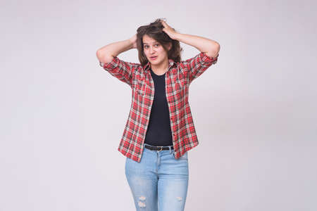 portrait of a beautiful brunette girl on a white background in jeans in different poses with...