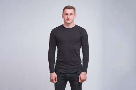 portrait of a cute young guy on a white background in different poses with different emotions. He stands directly in front of the camera and smilesの写真素材