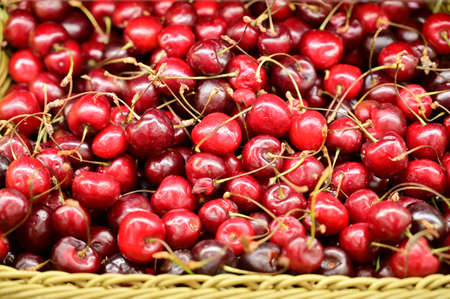 Photo of red cherry sweet berries ready for sale on a tray.
