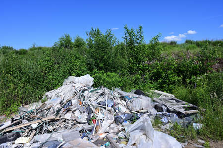 Photo of garbage in the field against the sky in sunny summer weather.の写真素材