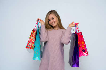young beautiful woman, happy smiling beautiful girl holding shopping bags on white backgroundの写真素材
