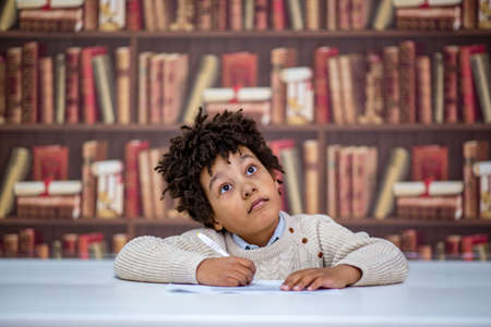 black boy on the background of books in the library