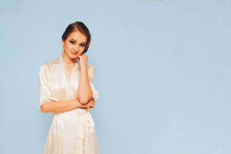 beautiful sweet girl in a silk dressing gown  in different posesの写真素材