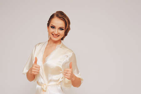 beautiful sweet girl in a silk dressing gown  in different posesの写真素材