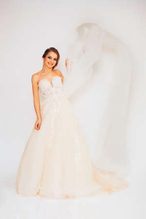 beautiful young bride in a wedding dress demonstrates different posesの写真素材