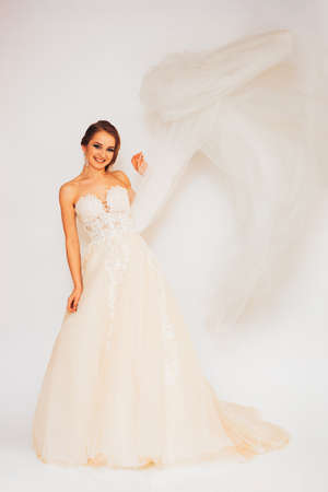 beautiful young bride in a wedding dress demonstrates different posesの写真素材