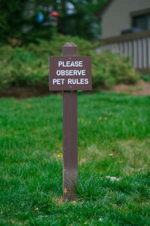 Brown plate of pet rules on grass backgroundの写真素材