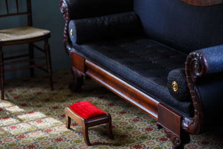 Red foot stool with black sofaの写真素材