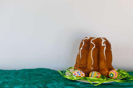 Easter cake and Easter eggs are lined with ribbons on a plateの写真素材