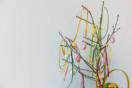 Easter branch with eggs and ribbons on the white backgroundの写真素材