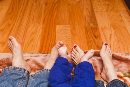 Family legs on a wooden background. baby, mom and dad. Mothers Day. Fathers Day.の写真素材