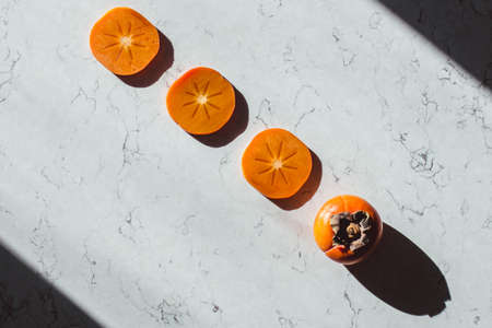 Persimmon slices straight line on a tableの写真素材