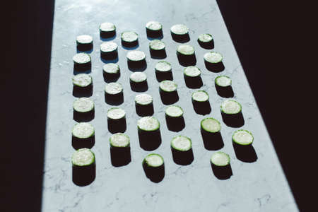 zucchini slices on a table with shadows