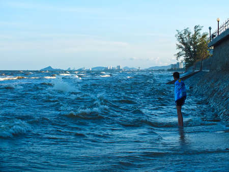 A boy standing on the seaside, longing  This event happen during the flood of Thailand in 2011の写真素材