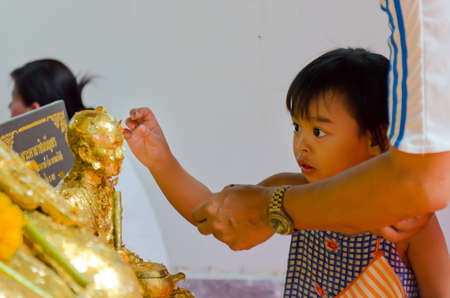 Wat Maitongsen Temple, Bangkok / 7 March 2012 is a Makha Bucha day. A father is teaching his little...