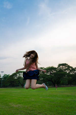 A cute Thai girl jumping with joyの写真素材