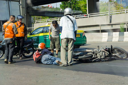 BANGKOK, THAILAND - APRIL 28: Motorcycle accidents on the street of Bangkok due to road slippery on April 28, 2012. People around that area gather to help the injury.のeditorial素材
