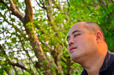 An office guy set off his mind in the middle of nature, free from all chaos in the city. He looks peacefulの写真素材