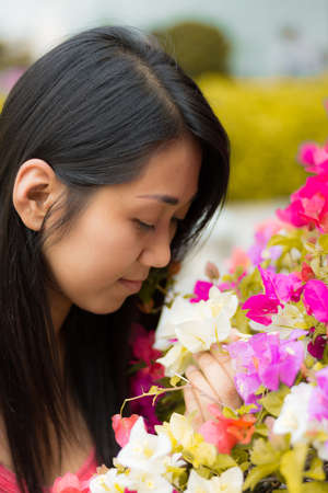 Cute Thai girl with pink colorful flowers.の写真素材