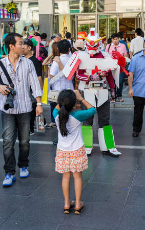 BANGKOK, THAILAND - MARCH 31: A young girl is photographing a Gundam cosplayer at the Thai-Japan anime festival on March 31, 2013. のeditorial素材