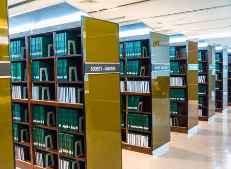 Row of green thesis in the large bookshelf in Chulalongkorn university of Thailand. It is full of Master degree knowledge.のeditorial素材