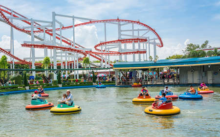 BANGKOK, THAILAND - 5 JUNE 2013: People with various age plays lifebuoy-shape boat with roller coaster background in in "Dream World" amusement park on June 5, 2013.のeditorial素材