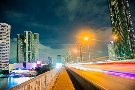 Main Highway of Bangkok at midnight with traffic lights and surrounding buildingsの写真素材