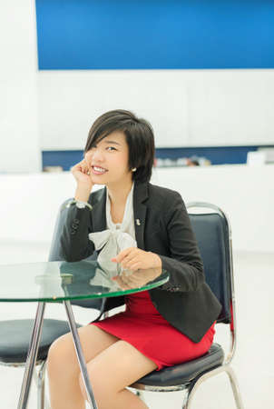 Cute Thai  Asian  businesswoman sitting in the office with a smiling welcome の写真素材