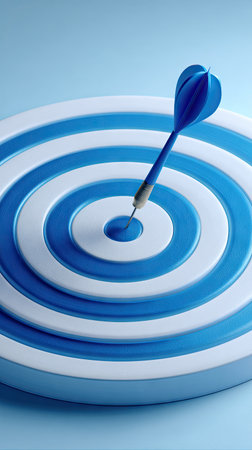 A dart precisely strikes the center of a target board, demonstrating precision and achievement. The composition features a bright blue and white color scheme, with overhead lighting. This image suits various commercial applications like business, marketing, or goal-oriented themes.の素材