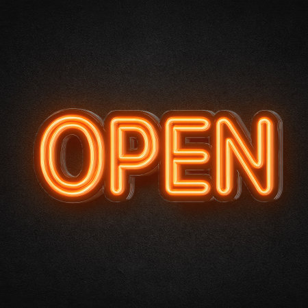 A neon sign spelling OPEN is prominently featured against a dark backdrop. The word glows with an orange hue, emitting light and highlighting the letters. The composition uses a close-up perspective, emphasizing the sign's visual appeal and its potential for commercial applications. The background is plain and provides a good contrast.の素材