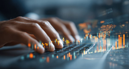 Hands are seen typing on a laptop keyboard. The image incorporates a data visualization overlay in shades of orange and blue. The composition focuses on digital interaction and technological processes, suggesting modern communication and information exchange. This could be used for illustrating technology concepts or business communications.の素材