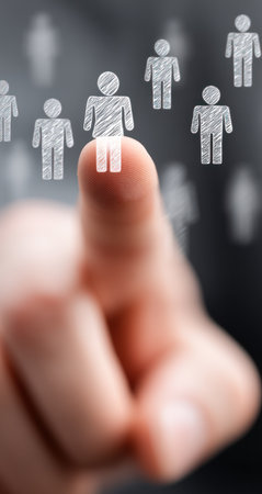 A hand points towards a sketched human figure, highlighting it against other similar figures in a blurred background. The image features a shallow depth of field, with a focus on the finger and chosen figure. It presents a simple style, suitable for various business or editorial uses related to decision-making or selection.の素材