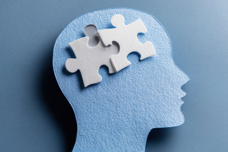 A blue silhouette of a human head features two white puzzle pieces, suggesting concepts of thought and understanding. The close-up composition highlights the texture of the material against a complementary blue background. The image's clean aesthetic lends itself to various commercial and conceptual applications.の素材
