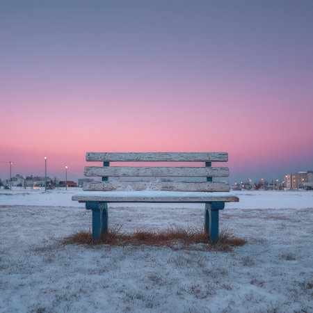 An aged wooden bench sits atop snow-covered ground against a vibrant sky of pink and blue hues. The composition features a symmetrical balance with the bench as the central element. The cool tones of the winter scene create a sense of serenity. Suitable for diverse applications, including illustrating nature's beauty.の素材