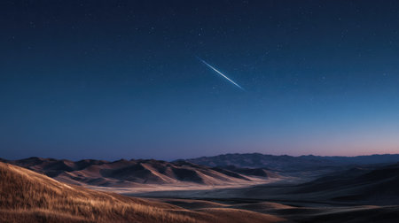 A breathtaking night scene depicts rolling hills and distant mountains under a dark blue sky. The composition emphasizes the contrast between the earth's terrain and celestial elements. Atmospheric perspective adds depth, while the overall lighting suggests a twilight or night environment. Suitable for editorial and commercial applications.の素材