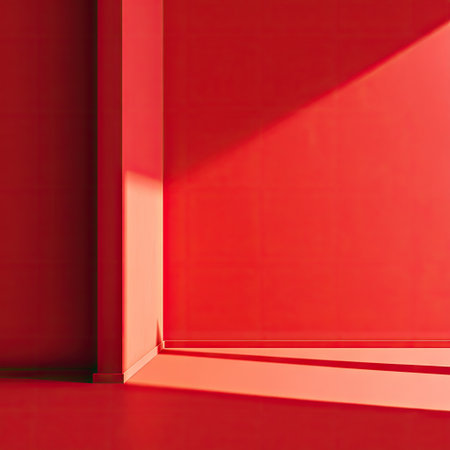 This image showcases a minimalist interior with red walls and a play of light and shadow. The composition highlights geometric forms, with clear lines and sharp angles. The lighting creates a dramatic effect, accentuating the textures. Suitable for illustrating concepts of design, space, and modern aesthetics, it is useful in various editorial and commercial applications.の素材