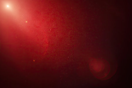 This image features an abstract red background with light effects and a textured overlay. The composition showcases a gradient of dark and light shades, creating a sense of depth. Suitable for various creative projects, this image can be used as a backdrop, or as a design element in both commercial and editorial contexts.の素材