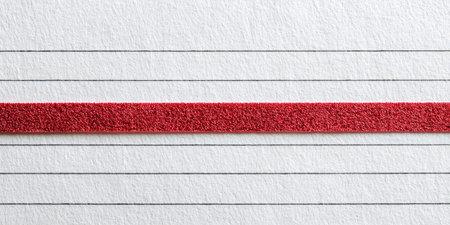 A close-up view displays a textured red line against a backdrop of lined paper. The composition is simple, featuring horizontal lines in gray and a vibrant red accent. This image offers a clean, graphic aesthetic, suitable for various design applications. It can be utilized in editorial content and commercial projects.の素材