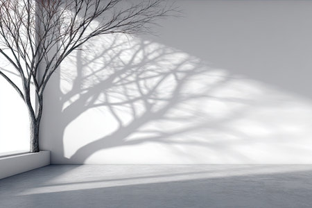 An interior scene features a tree casting a shadow on a white wall. The composition highlights contrasting shadows against a bright background, emphasizing clean lines and negative space. The image presents a minimalist aesthetic, suitable for use in design projects, advertising, or as a backdrop.の素材