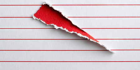 An image showcases a piece of lined paper, partially torn to reveal a red backdrop. The paper features horizontal red lines. The visual composition employs a diagonal tear. This could be used for various design, concept, or editorial purposes. The texture of the paper and the contrast of colors enhance visual interest.の素材