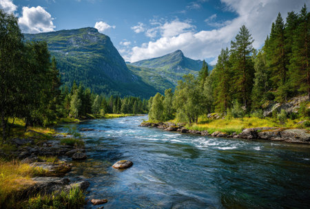 A river carves its path through a verdant valley, surrounded by towering mountains and vibrant trees. The composition highlights the water's flow and the natural beauty of the environment. The image uses natural lighting to capture the scene, potentially suitable for various commercial or editorial applications.の素材