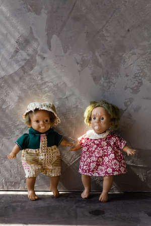 Ugly and scary dolls isolated in front of gray background.