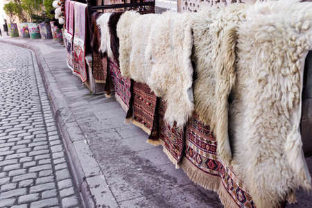 National carpets with Caucasian patterns are for sale in the old town on old stonesの写真素材